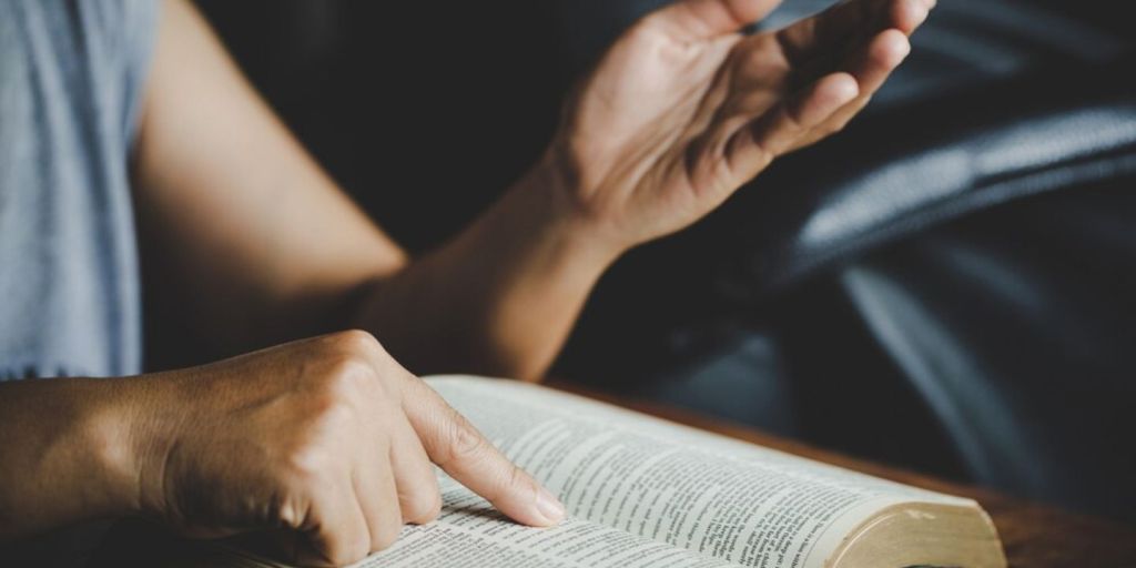 reading the bible while pointing the finger to the book and explaining