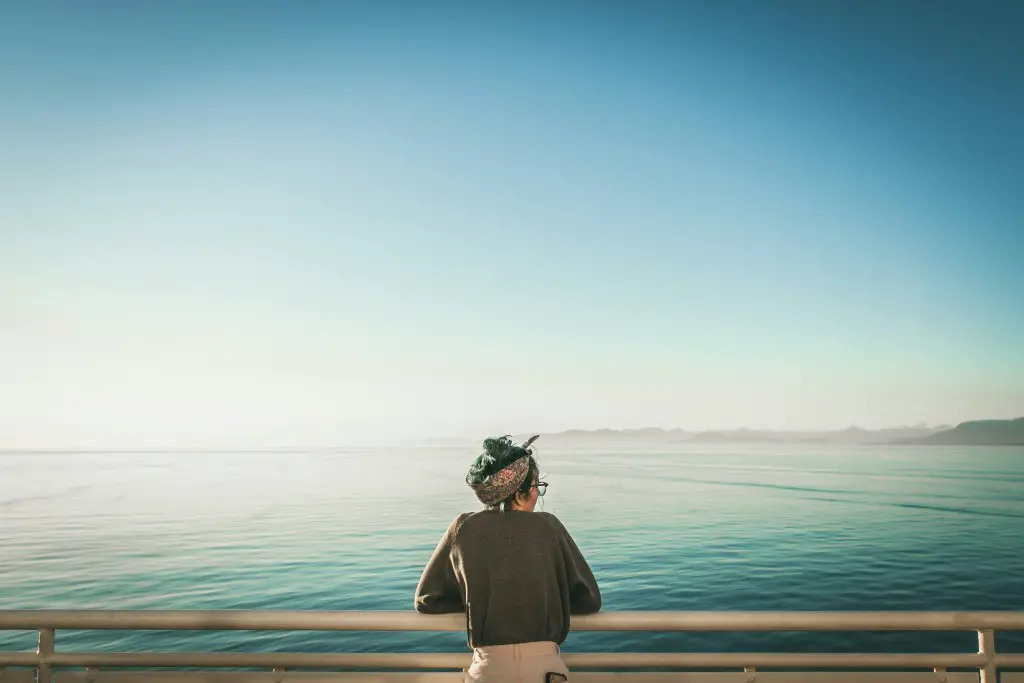 a woman looking far away by the beach ocean or sea