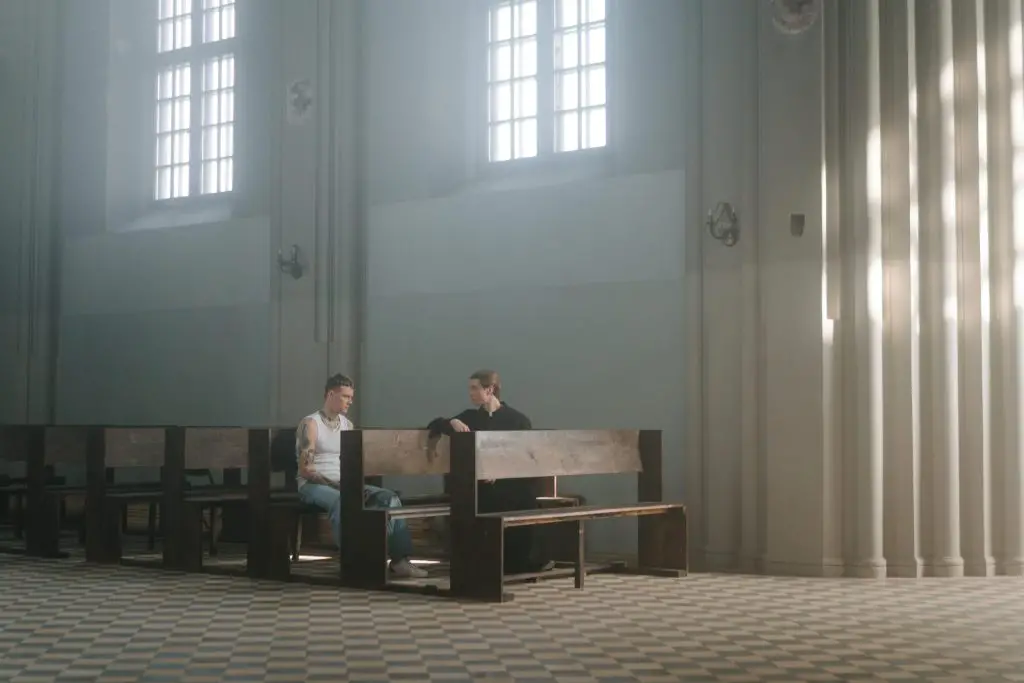 a man and a pastor talking inside the church about forgiveness