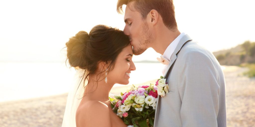 a man kissing his bride in a wedding attire