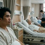 person on a hospital bed with other patients